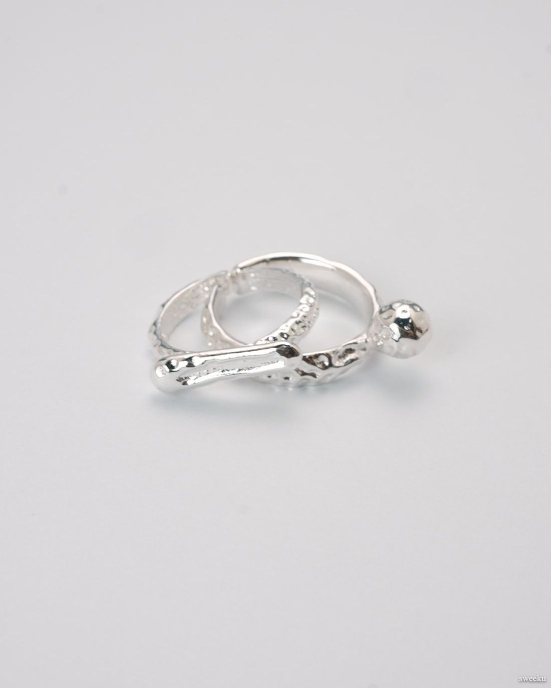 Adjustable silver molten-texture ring with a polished metal sphere accent on a white background.