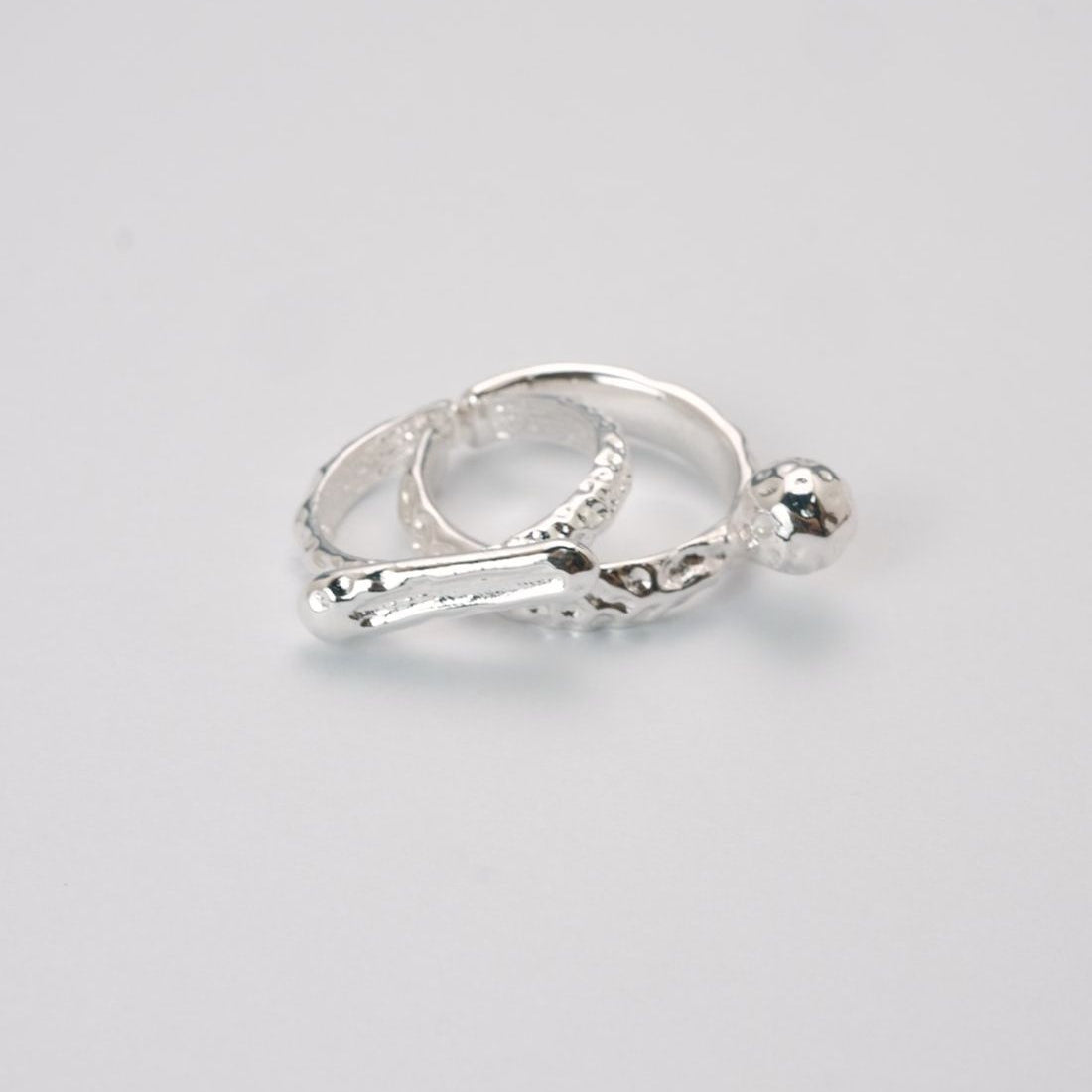 Adjustable silver molten-texture ring with a polished metal sphere accent on a white background.