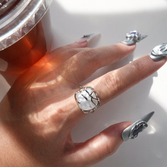 Top view of model wearing a baroque pearl cage ring showing the unique setting and irregular white pearl