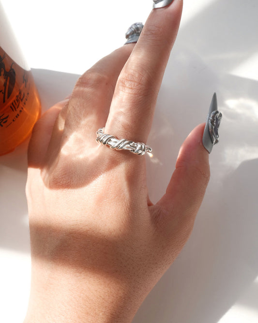 Model wearing braided sculptural metal ring with a twisted design and polished finish – Top view 2 - SWEEKU jewelry