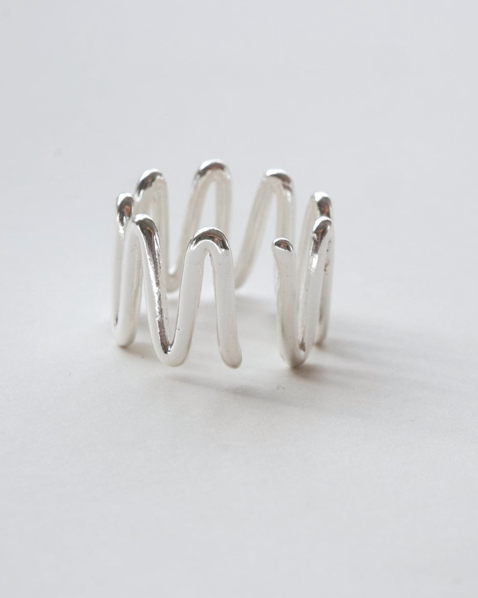 Front view of sculptural wavy line ring with a polished, fluid design and adjustable band