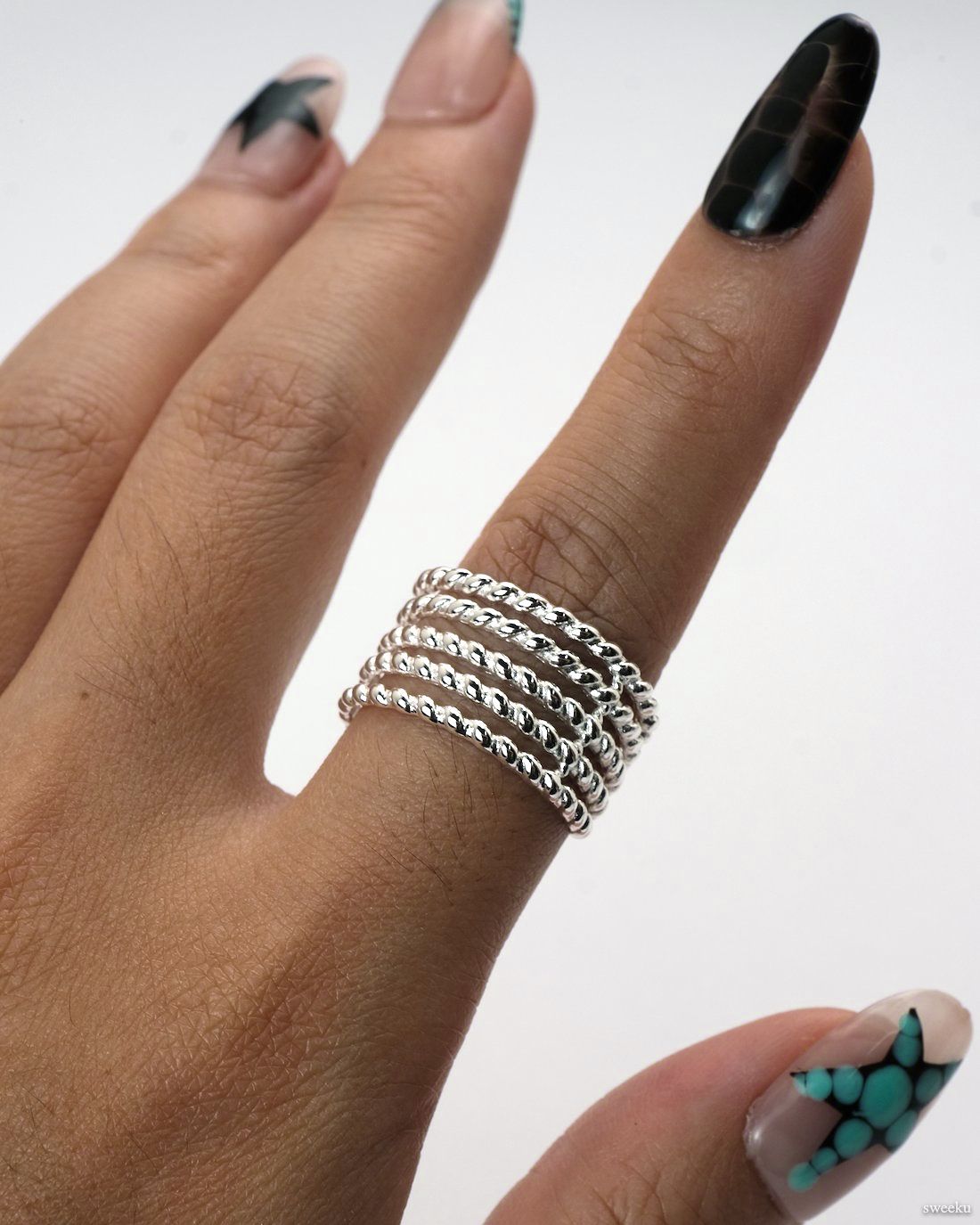 Adjustable silver multi-band twisted rope ring on white background