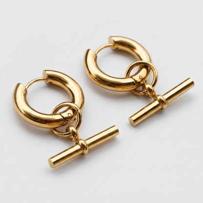 A pair of gold-toned hoop earrings with a matching horizontal bar toggle clasp, displayed on a clean light gray background.