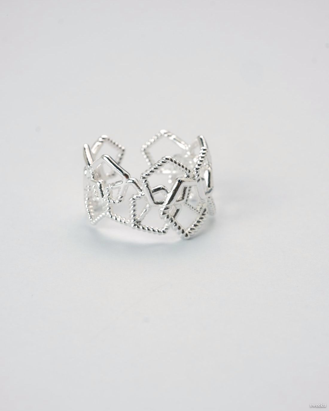Adjustable silver geometric open lattice ring on white background