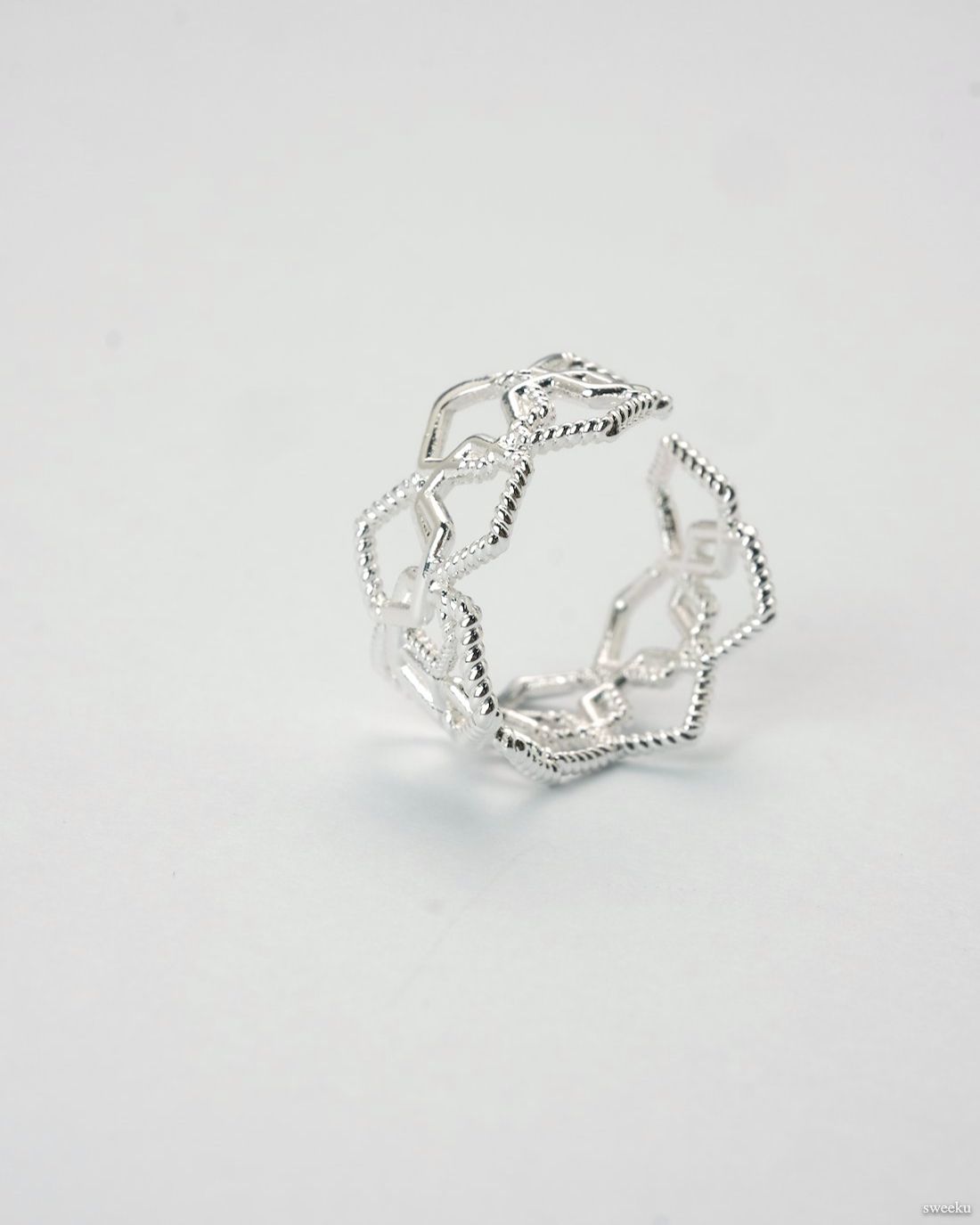 Adjustable silver geometric open lattice ring on white background