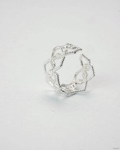 Adjustable silver geometric open lattice ring on white background