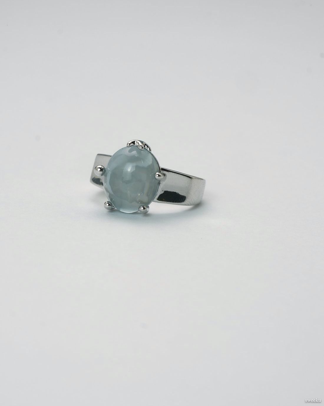 Adjustable silver ring with smooth grey gemstone centerpiece on white background