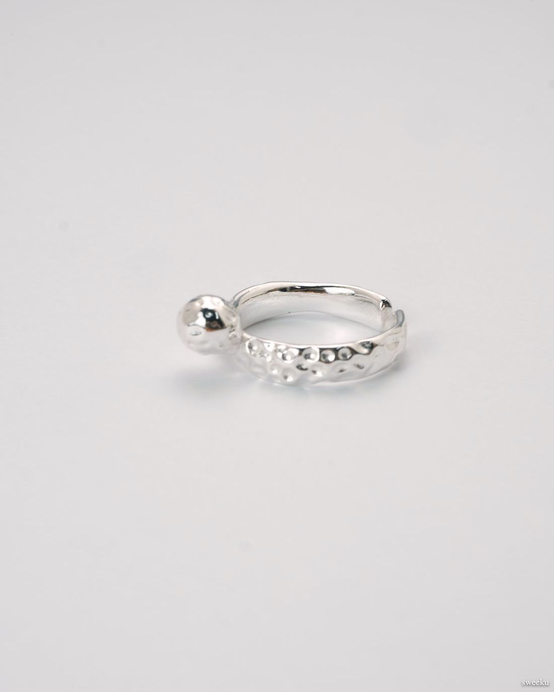 Adjustable silver molten-texture ring with a polished metal sphere accent on a white background.
