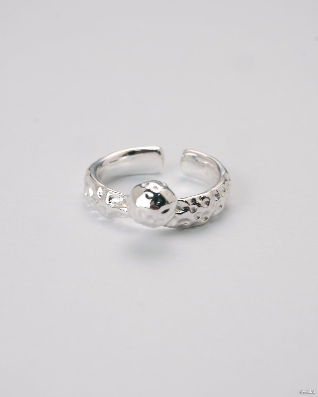 Adjustable silver molten-texture ring with a polished metal sphere accent on a white background.