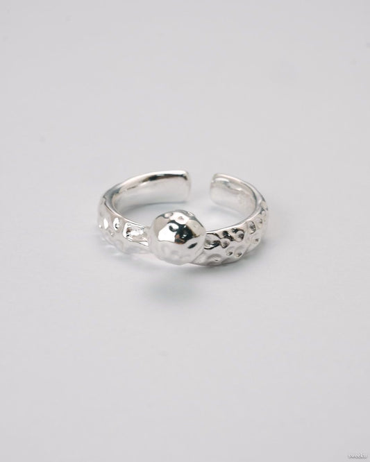 Adjustable silver molten-texture ring with a polished metal sphere accent on a white background.