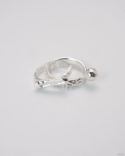 Adjustable silver molten-texture ring with a polished metal sphere accent on a white background.