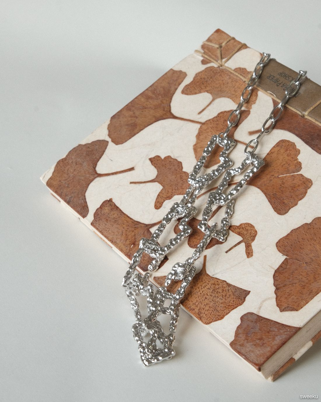 silver molten texture chain necklace on book background, adjustable length