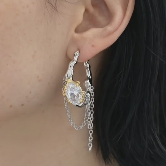 Melting metal chain dangle earrings worn on ear with asymmetrical chains