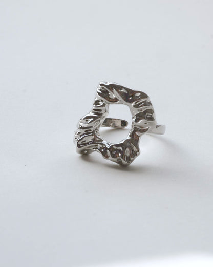 Front view of abstract molten sculptural ring with a polished, fluid design and adjustable band

