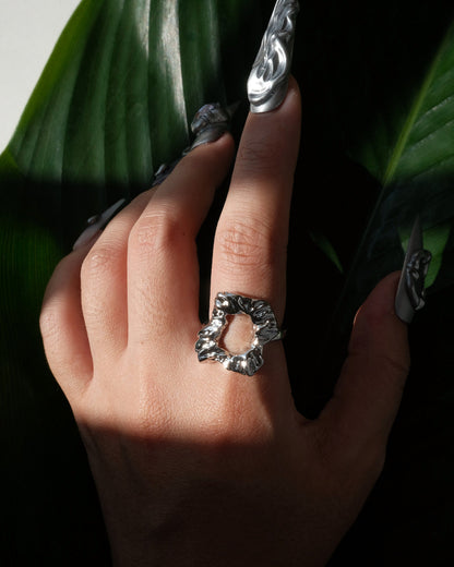 Front view of wearing abstract molten sculptural ring with a polished, fluid design and adjustable band
