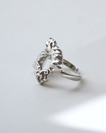 Side view of abstract molten sculptural ring with a polished, fluid design and adjustable band