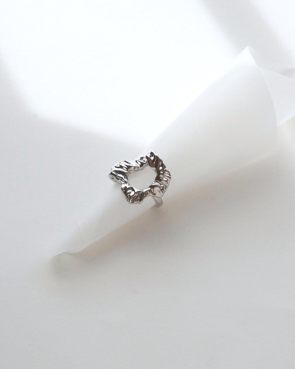 Top view of abstract molten sculptural ring with a polished, fluid design and adjustable band
