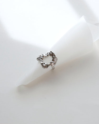 Top view of abstract molten sculptural ring with a polished, fluid design and adjustable band
