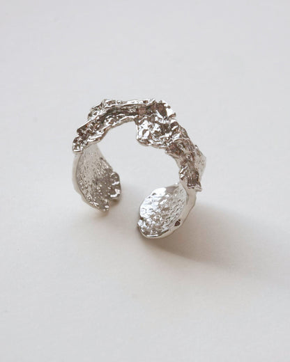 Front view of abstract textured sculptural ring with a wide, fluid design and adjustable band
