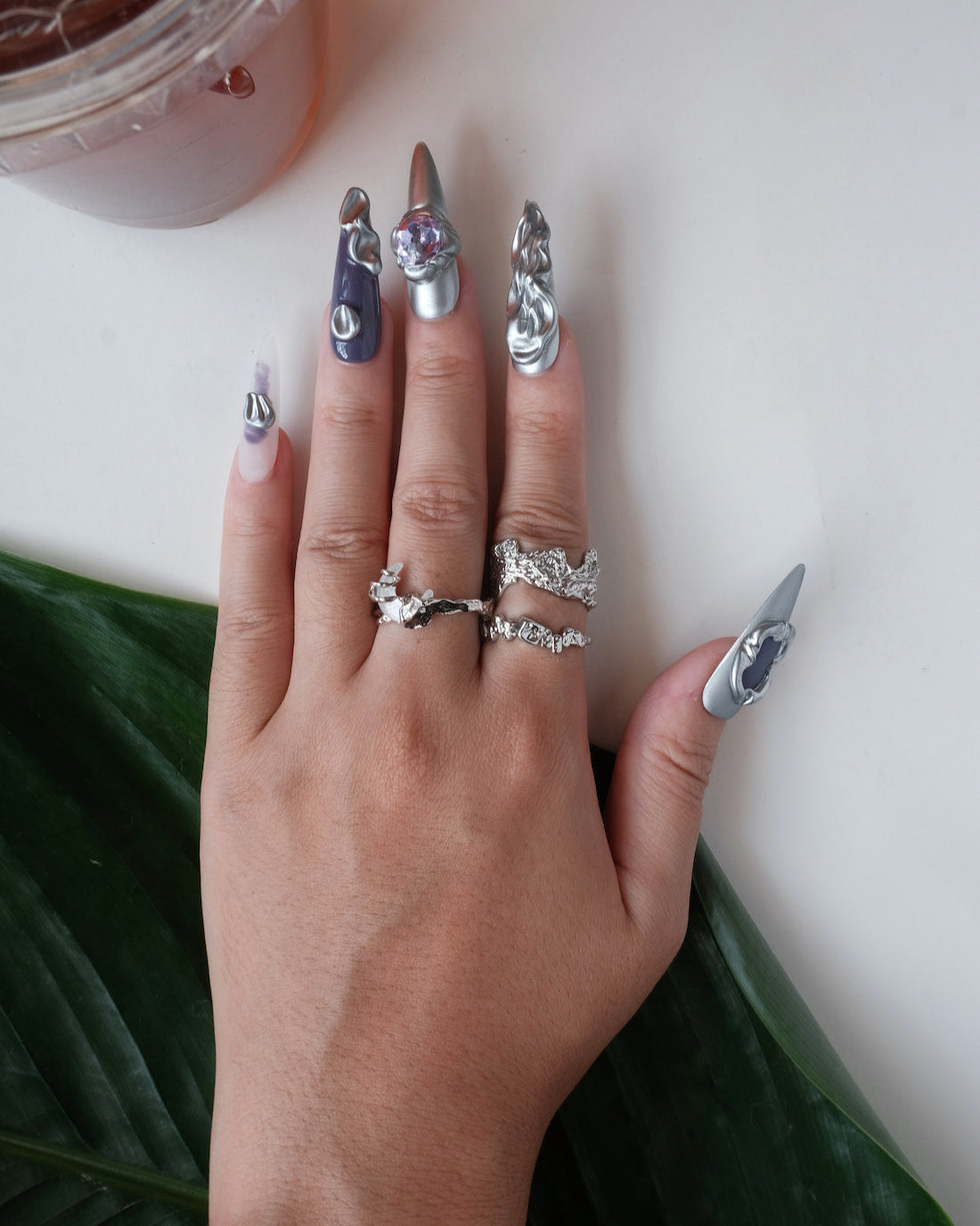 Wearing view of abstract textured sculptural ring with a wide, fluid design and adjustable band
