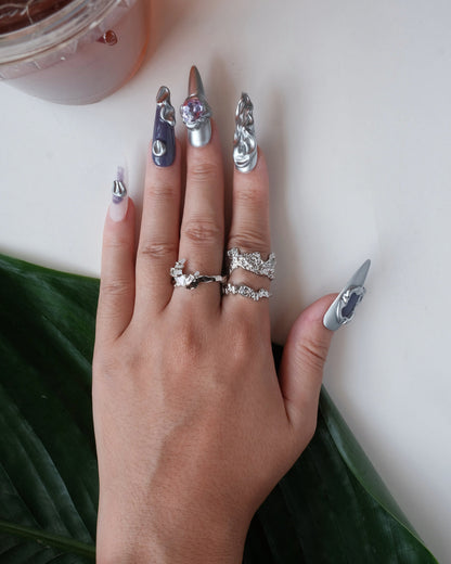 Wearing view of abstract textured sculptural ring with a wide, fluid design and adjustable band
