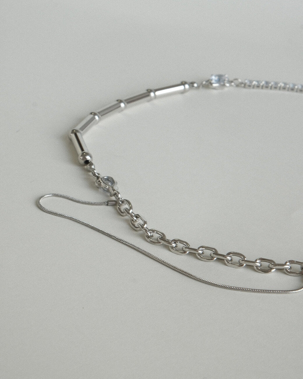 Asymmetrical pearl and zirconia necklace with a mix of chains, beads, and polished bars - chain detail - side view - SWEEKU jewelry