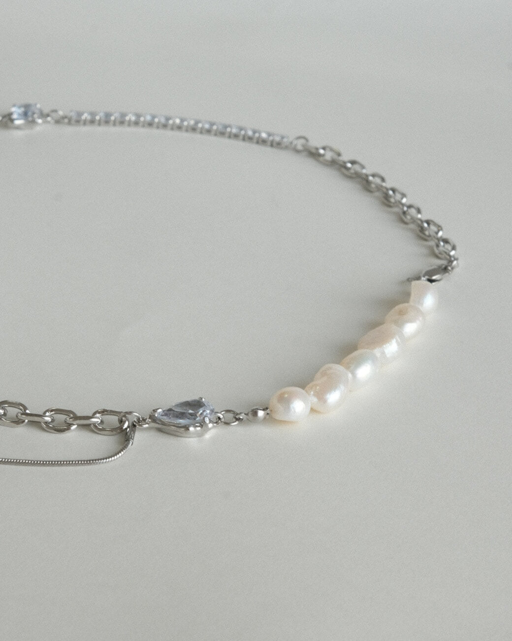 Asymmetrical pearl and zirconia necklace with a mix of chains, beads, and polished bars - detail - pearl - side view - SWEEKU jewelry