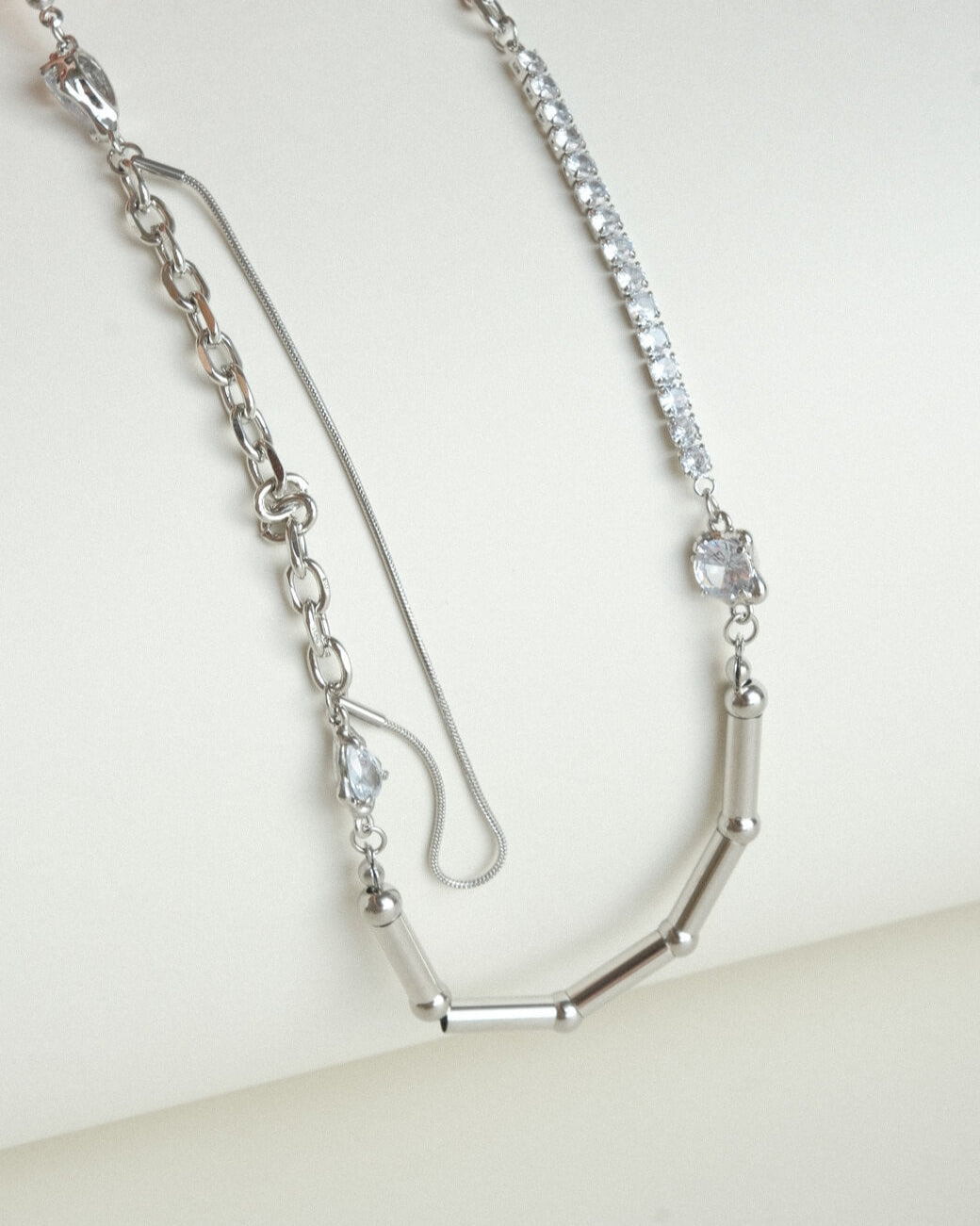 Asymmetrical pearl and zirconia necklace with a mix of chains, beads, and polished bars - stones detail - front view - SWEEKU jewelry