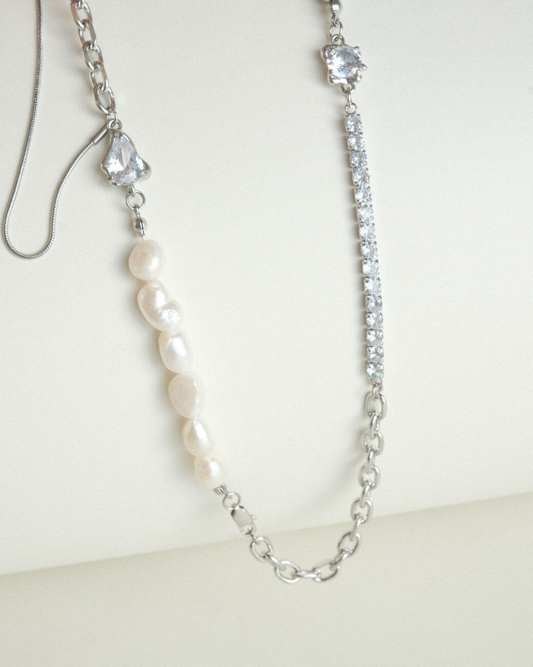 Asymmetrical pearl and zirconia necklace with a mix of chains, beads, and polished bars - front view - SWEEKU jewelry