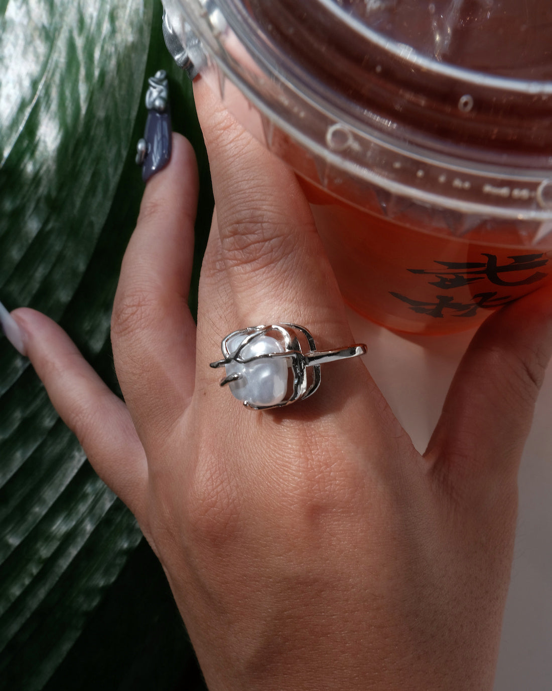 Side view of model wearing a baroque pearl cage ring showing the unique setting and irregular white pearl