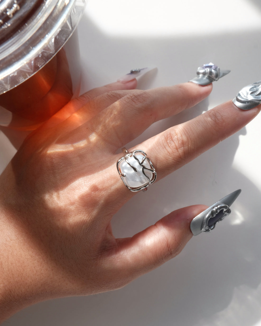 Top view of model wearing a baroque pearl cage ring showing the unique setting and irregular white pearl