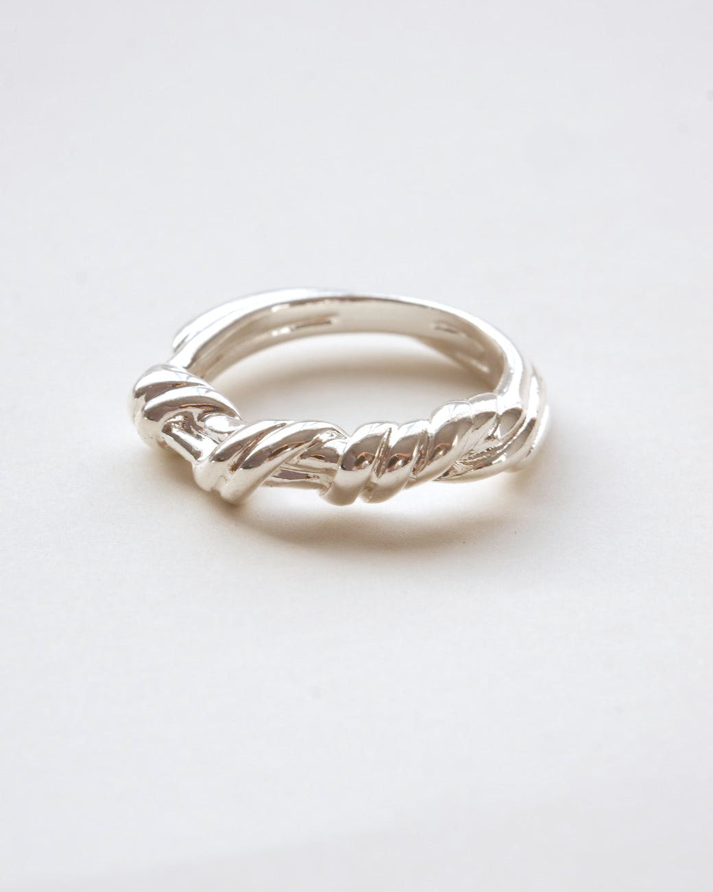 Braided sculptural metal ring with a twisted design and polished finish – front view – SWEEKU jewelry