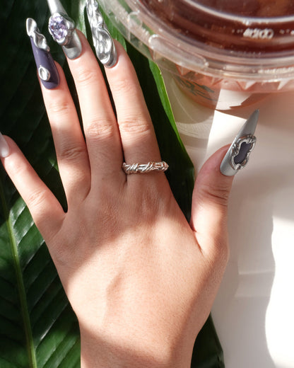 Model wearing braided sculptural metal ring with a twisted design and polished finish – Top view 3 – SWEEKU jewelry