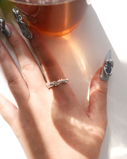 Model wearing braided sculptural metal ring with a twisted design and polished finish – Top view – SWEEKU jewelry