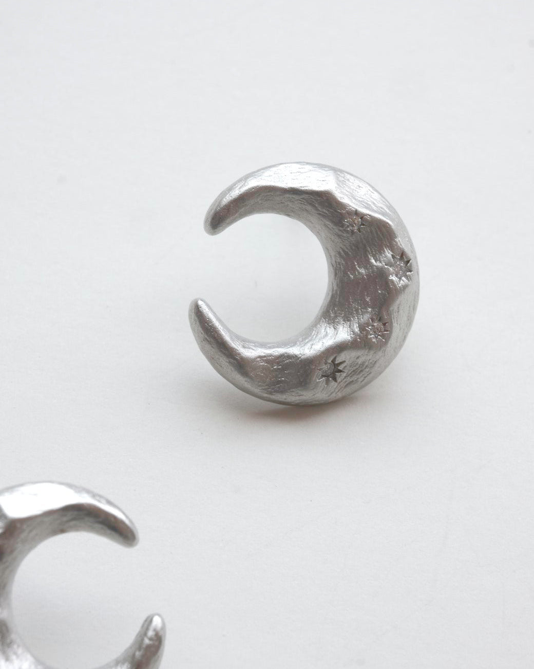 Pair of celestial crescent moon stud earrings crafted from textured copper with embedded stars and silver posts – detail - side view – SWEEKU jewelry