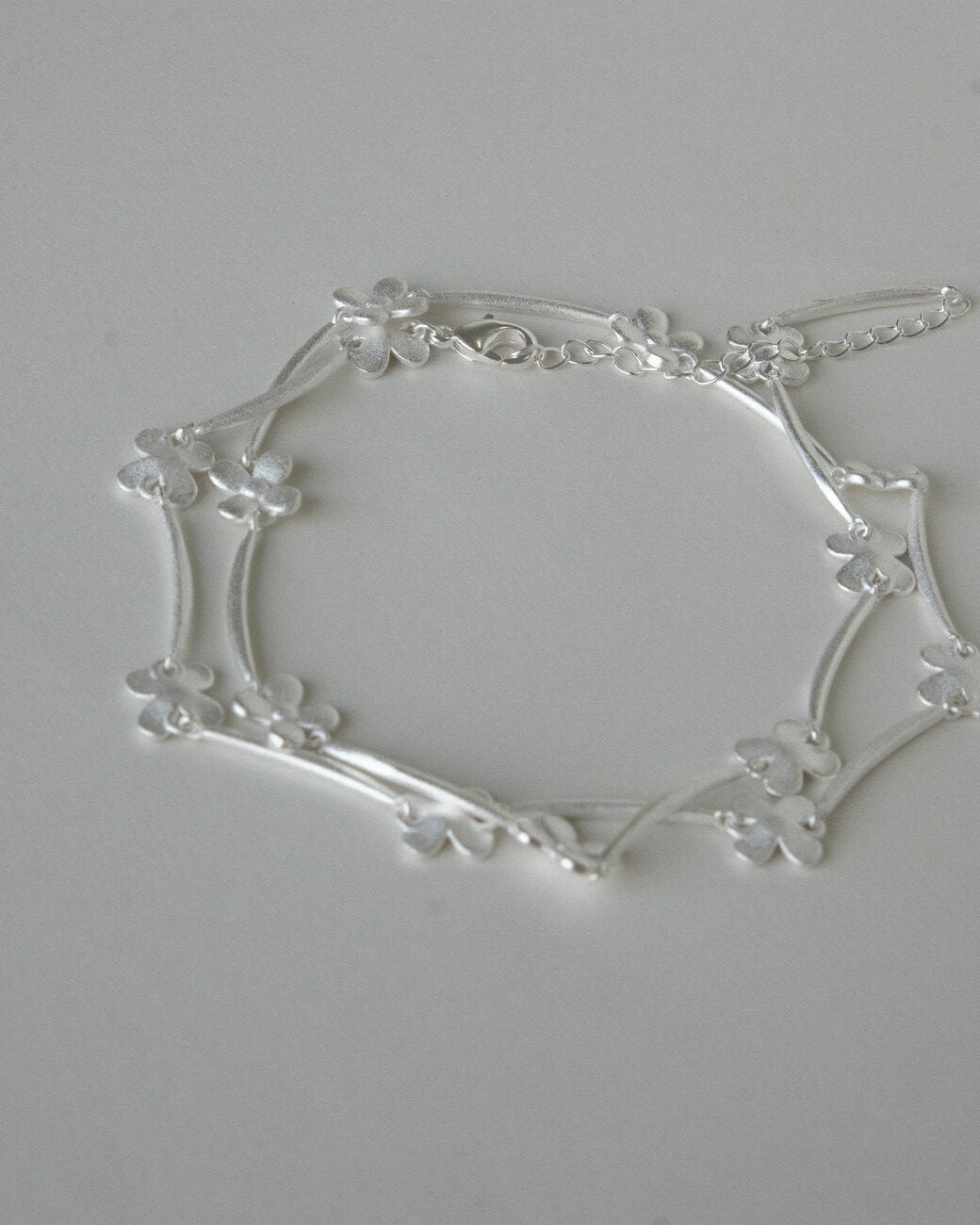 Dainty daisy chain necklace with small, polished floral links - side view - 3th - SWEEKU jewelry