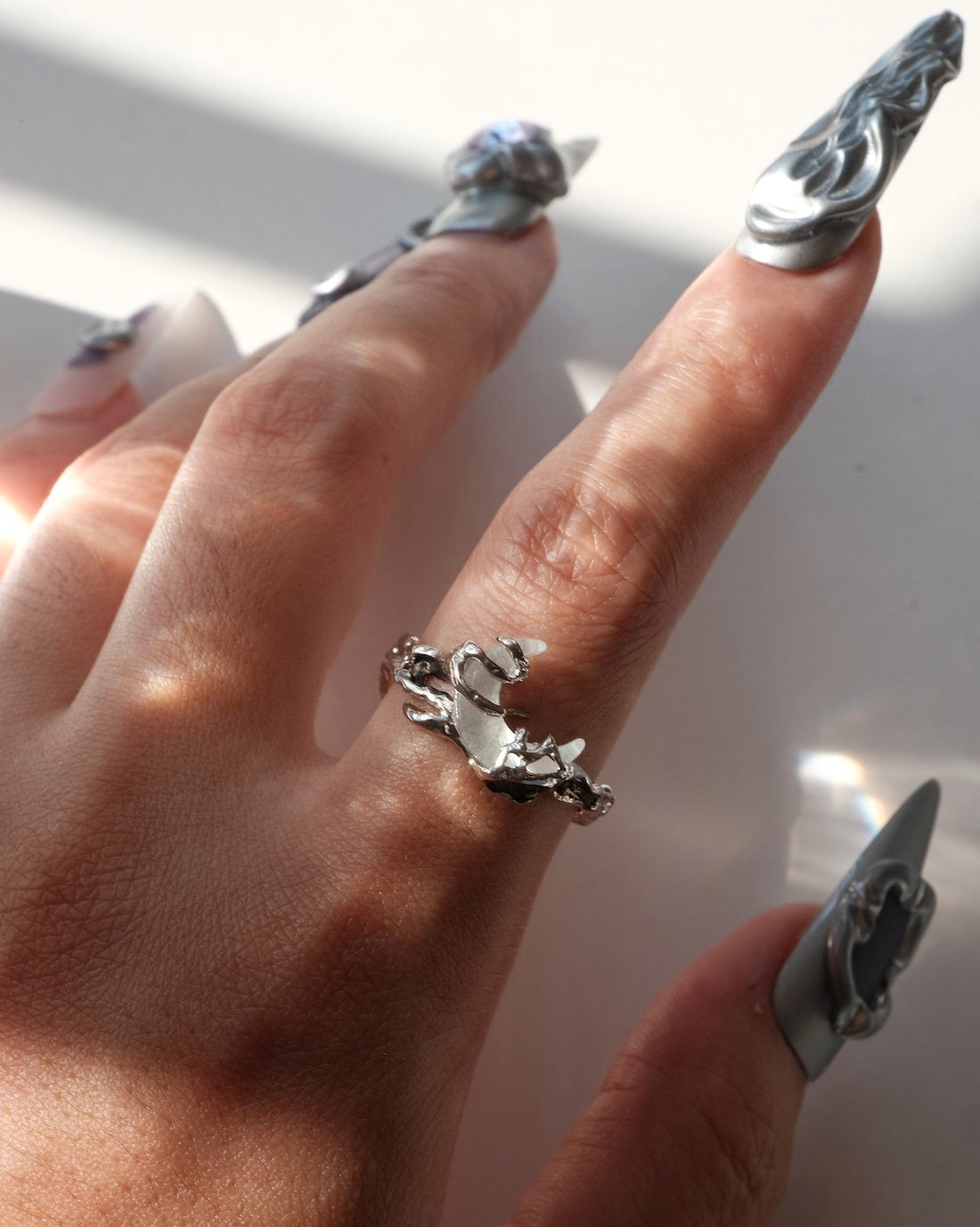 Model wearing dragon claw ring with an adjustable open band and a clear crystal centerpiece – front view – SWEEKU jewelry