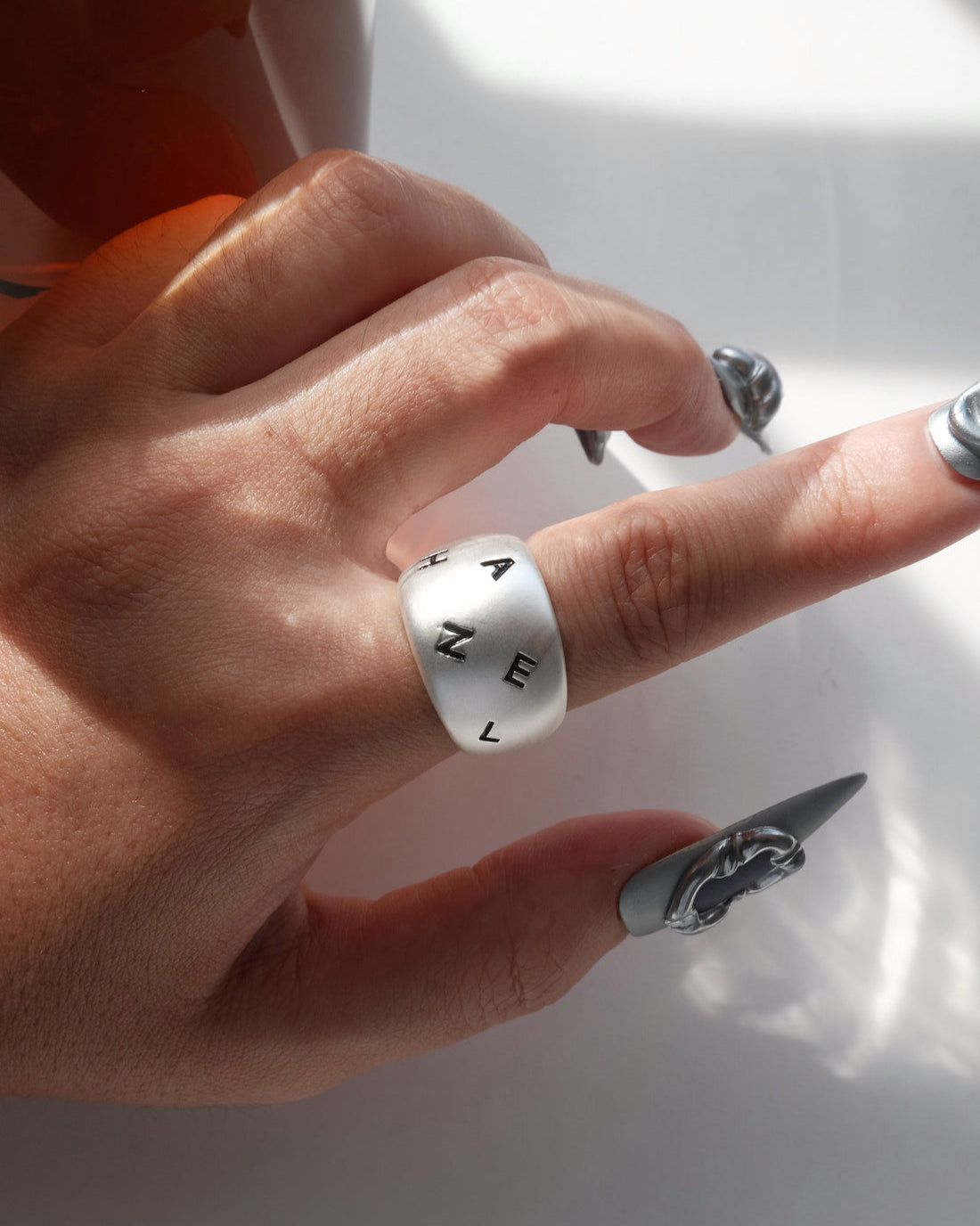 Model wearing engraved chunky copper band ring with a brushed finish and adjustable open band – top view – SWEEKU jewelry
