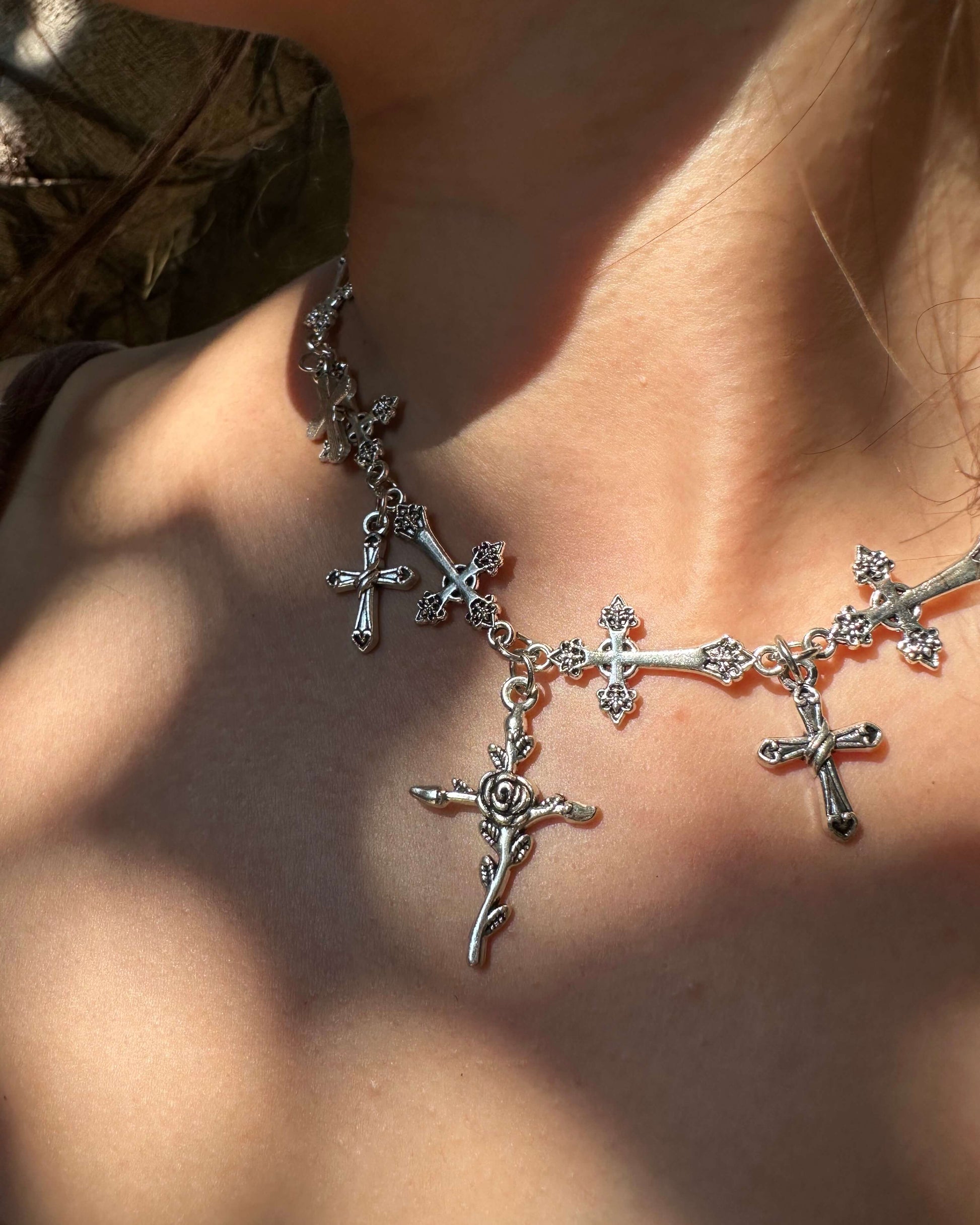 Woman wearing a gothic alloy chain necklace with various cross and rose charms - front view - SWEEKU jewelry