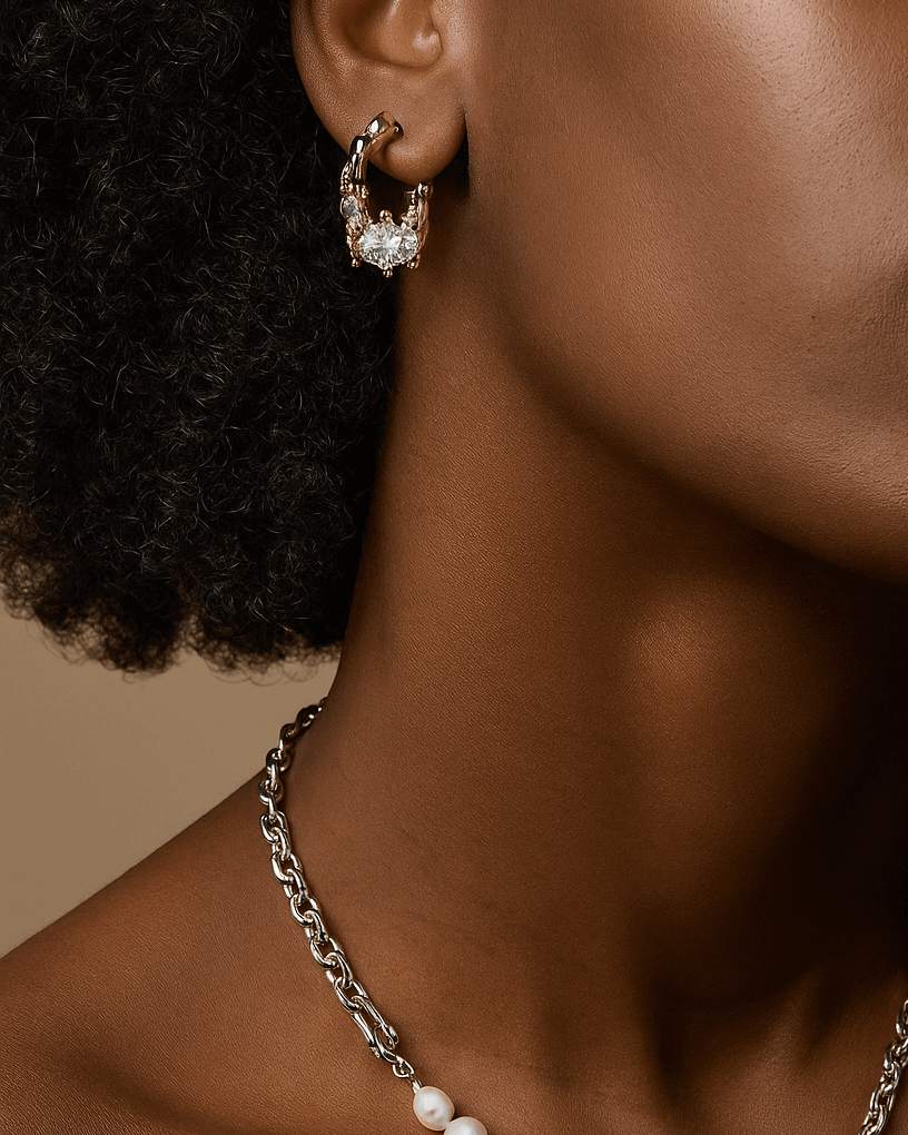 Model wearing pair of unique melting metal two-tone copper hoop earrings with dangling chains and an oval crystal - front view - SWEEKU jewelry