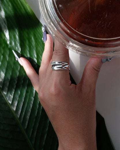 Model wearing sculptural molten metal ring with a polished, fluid design and adjustable band – side view – SWEEKU jewelry
