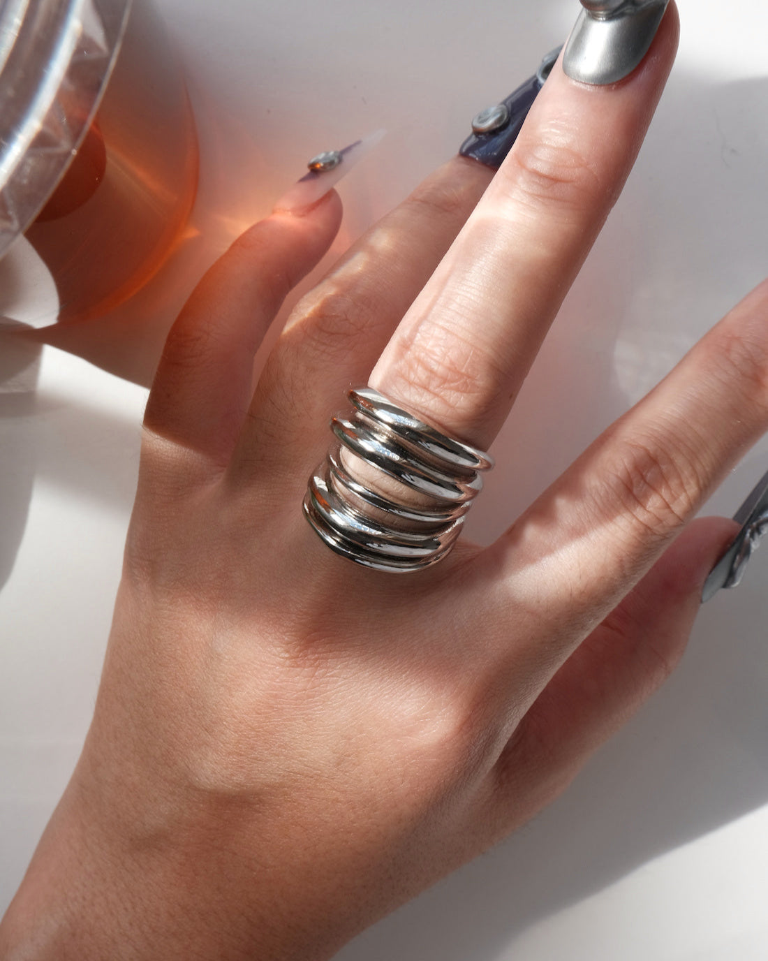 Model wearing multi-layer sculptural statement ring with a polished, stacked band design – detail view – SWEEKU jewelry