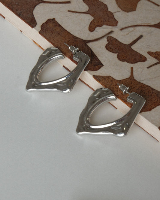 Pair of unique organic shape metal hoop earrings with a hammered texture and polished finish - side view - SWEEKU jewelry