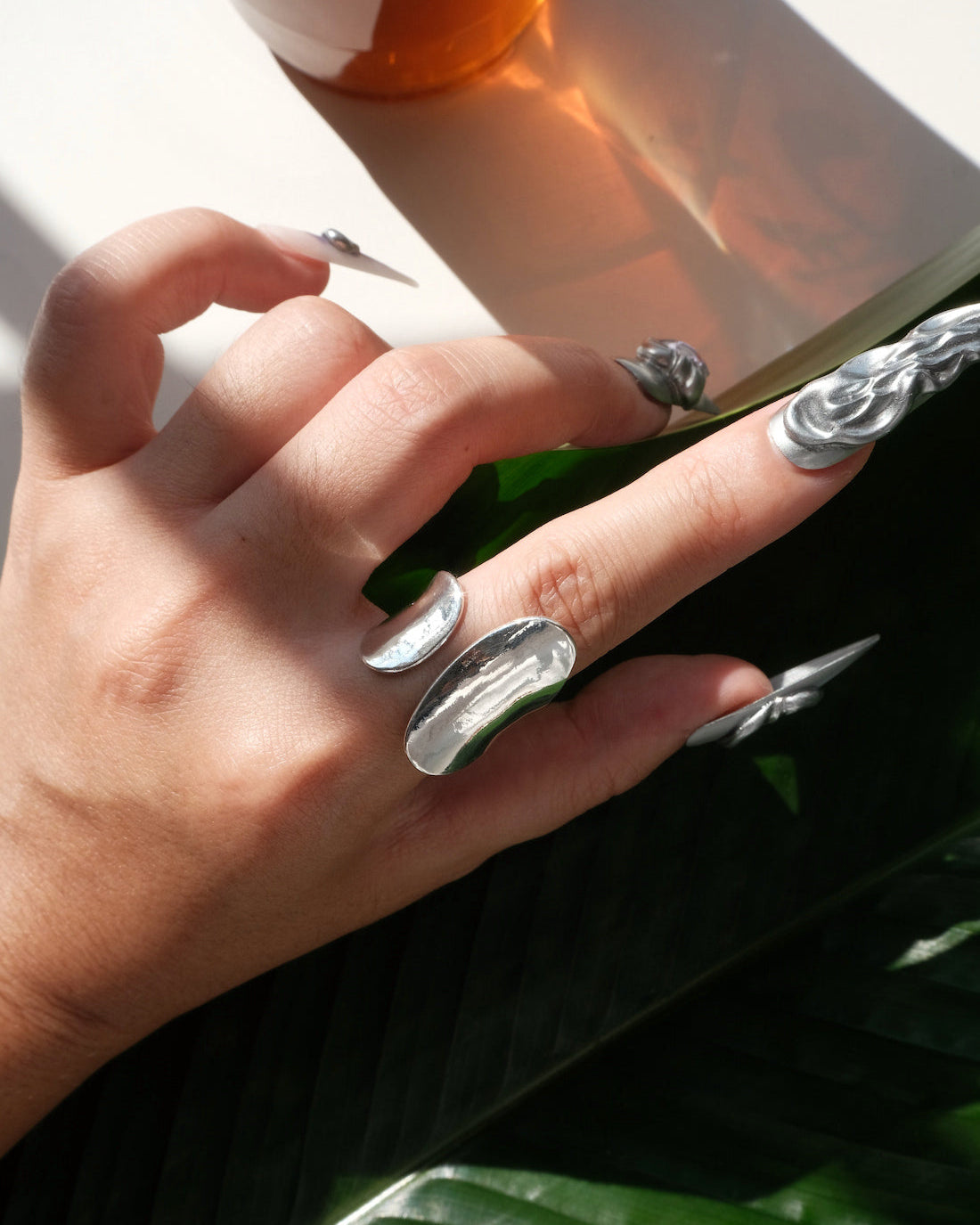 Model wearing sculptural fluid open ring with a polished finish and adjustable band – top view – SWEEKU jewelry