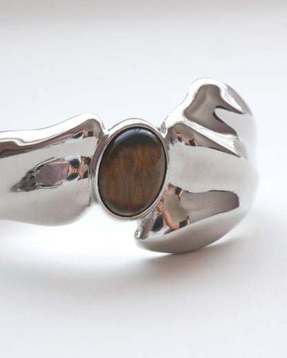 Sculptural liquid metal cuff bracelet with a polished finish and a central Tiger's Eye gemstone – front view detail – SWEEKU jewelry
