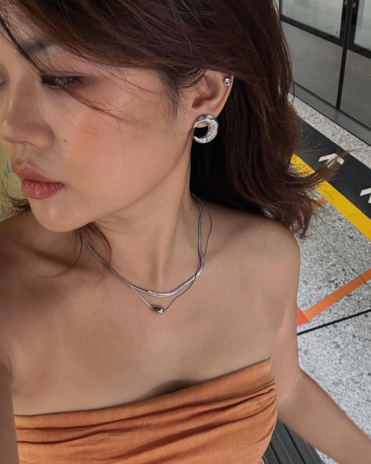 Model wearing two-layer snake chain necklace with a small, polished tear drop pendant - front view - SWEEKU jewelry
