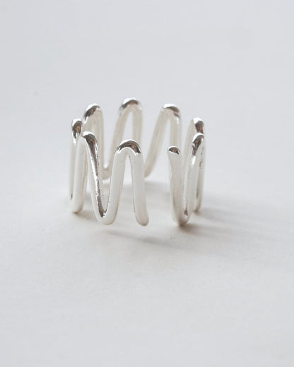 Front view of sculptural wavy line ring with a polished, fluid design and adjustable band

