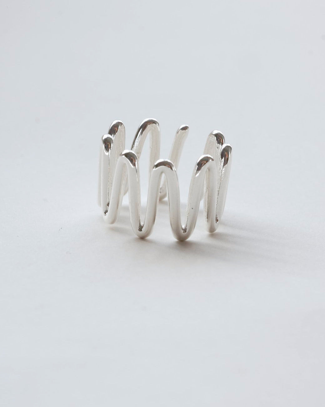 Sculptural wavy line ring with a polished, fluid design and adjustable band