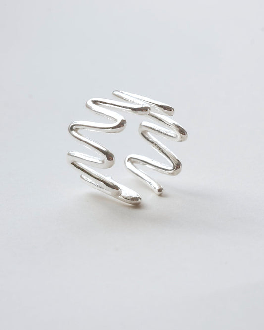 side view of sculptural wavy line ring with a polished, fluid design and adjustable band