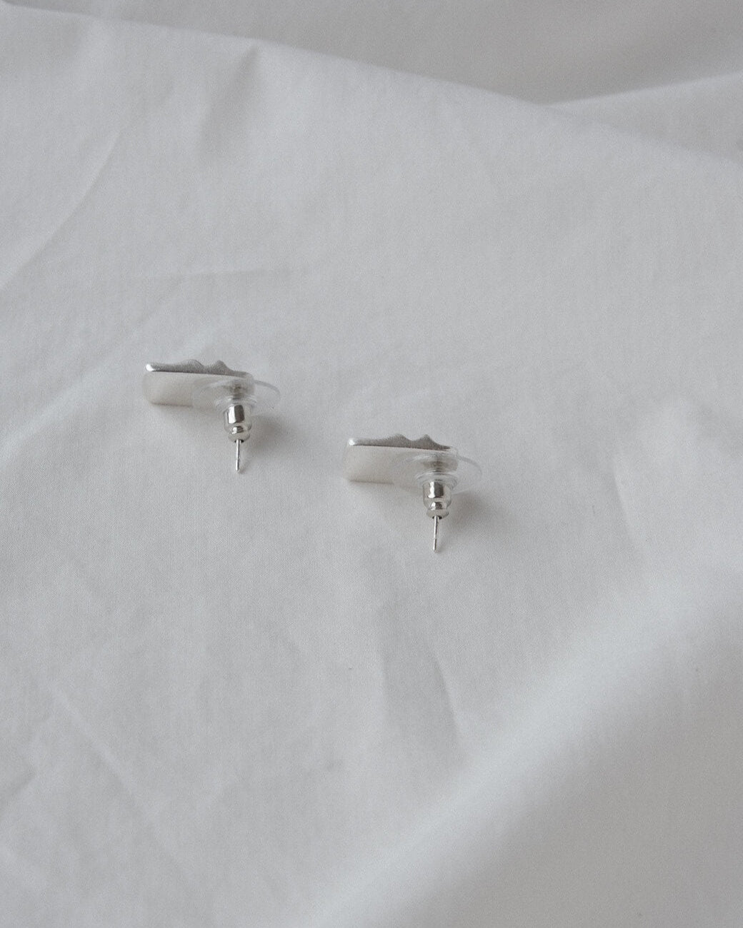 Pair of wavy rectangle copper stud earrings with silver posts and a textured, modern design - back view - SWEEKU jewelry